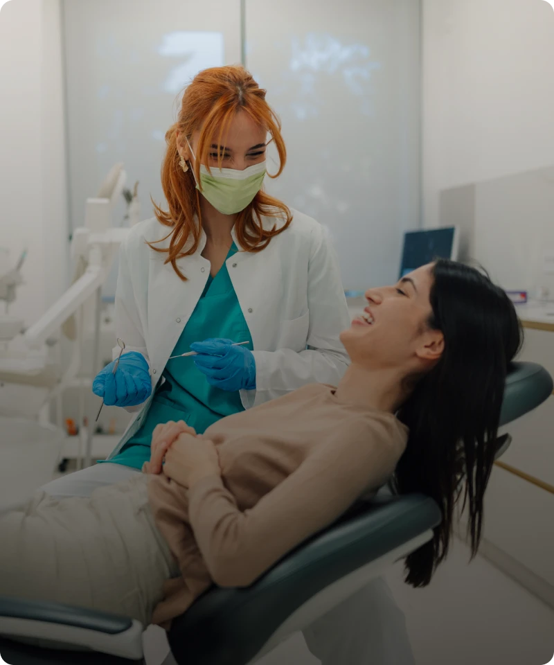 Dentist and patient smiling together